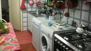 A compact kitchen with a washing machine, a stove, and various kitchen utensils and appliances. - 3 Bedroom Villa in Massa (Massa)