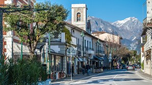 A street with buildings, a bell tower, and a mountain in the background. - 3 Bedroom Villa in Massa (Massa)