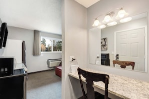 A bathroom with a sink, mirror, and overhead lighting. - River View Condo- Edge of Downtown (Bend)