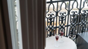 A balcony with ornate metal railings and a round table with two glasses of red wine. - SKY DE LOIOS - Charming apartment with balcony (Porto)
