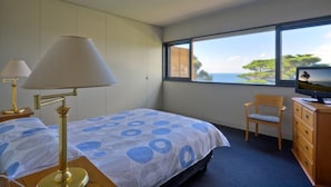 A hotel room with a bed, two lamps, a TV, a chair, and a dresser. -  Emanjay: Walk to Beach, Million Dollar Bay Views! Mineral Spa (Mount Martha)