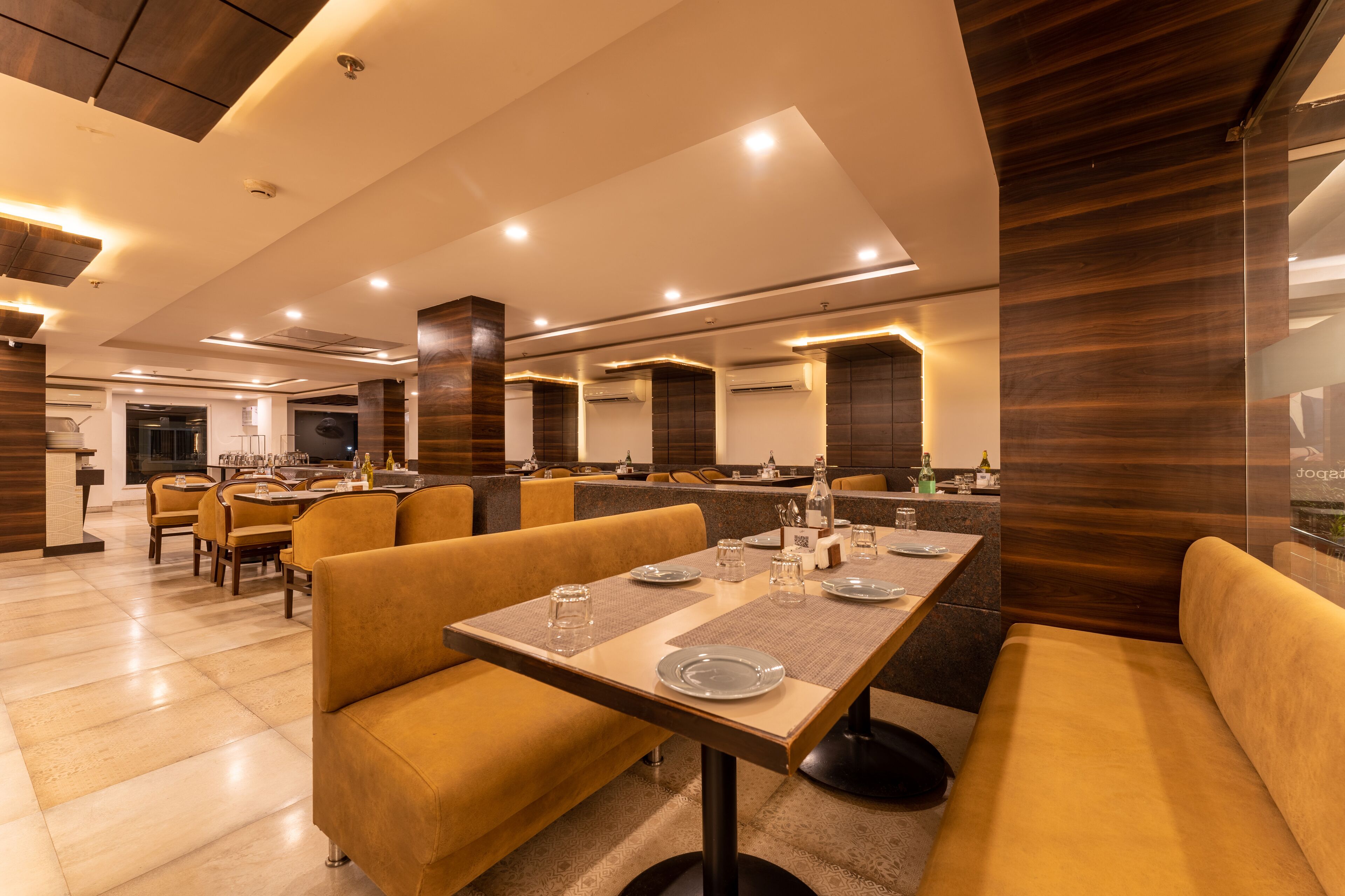 Un restaurant moderne avec des tables hautes et des sièges rembourrés.