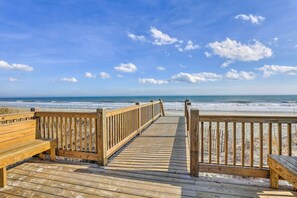 Una passerella in legno che conduce a una spiaggia con vista libera sull'oceano.