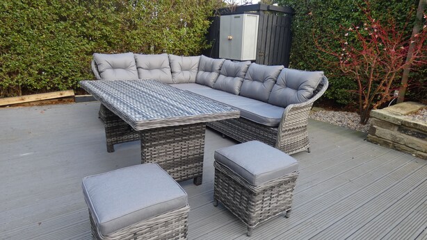 Un canapé modulable assorti d’un pouf et d’une table basse en osier, le tout placé sur une terrasse.