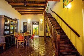 Stunning interior with exposed beams, a wooden staircase, and a large ornate door.