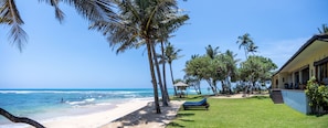 Ein Strand mit Palmen, ein Pool und ein Gebäude mit Außenbereich.