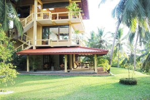 Guests can enjoy a balcony with a covered outdoor seating area overlooking well-maintained gardens.