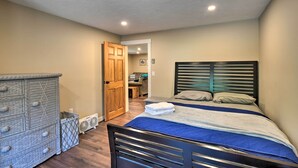 A bedroom with a bed, dresser, and a door leading to another room. - Gilford Escape w/ Boat Slip on Sanders Bay! (Gilford)