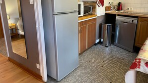Una cocina compacta equipada con refrigerador, microondas y lavavajillas.