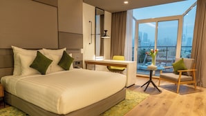 A modern hotel room with a large bed, a desk, and a view of the city skyline. - Al Khoory Courtyard Hotel (Dubai)