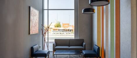 A modern waiting area with a sofa, chairs, and a coffee table.
