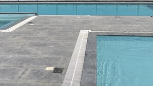 A rooftop pool with a city skyline in the background. - Al Khoory Courtyard Hotel (Dubai)