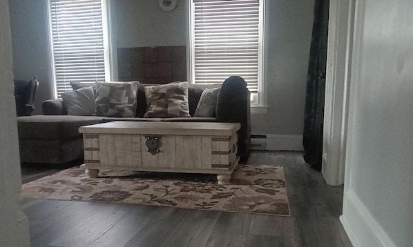 A living room with a couch, a storage chest, and a patterned rug. - Old Farmhouse/Available Horse And Buggy Rides/ Fire pit/ Waterslides (Gap)
