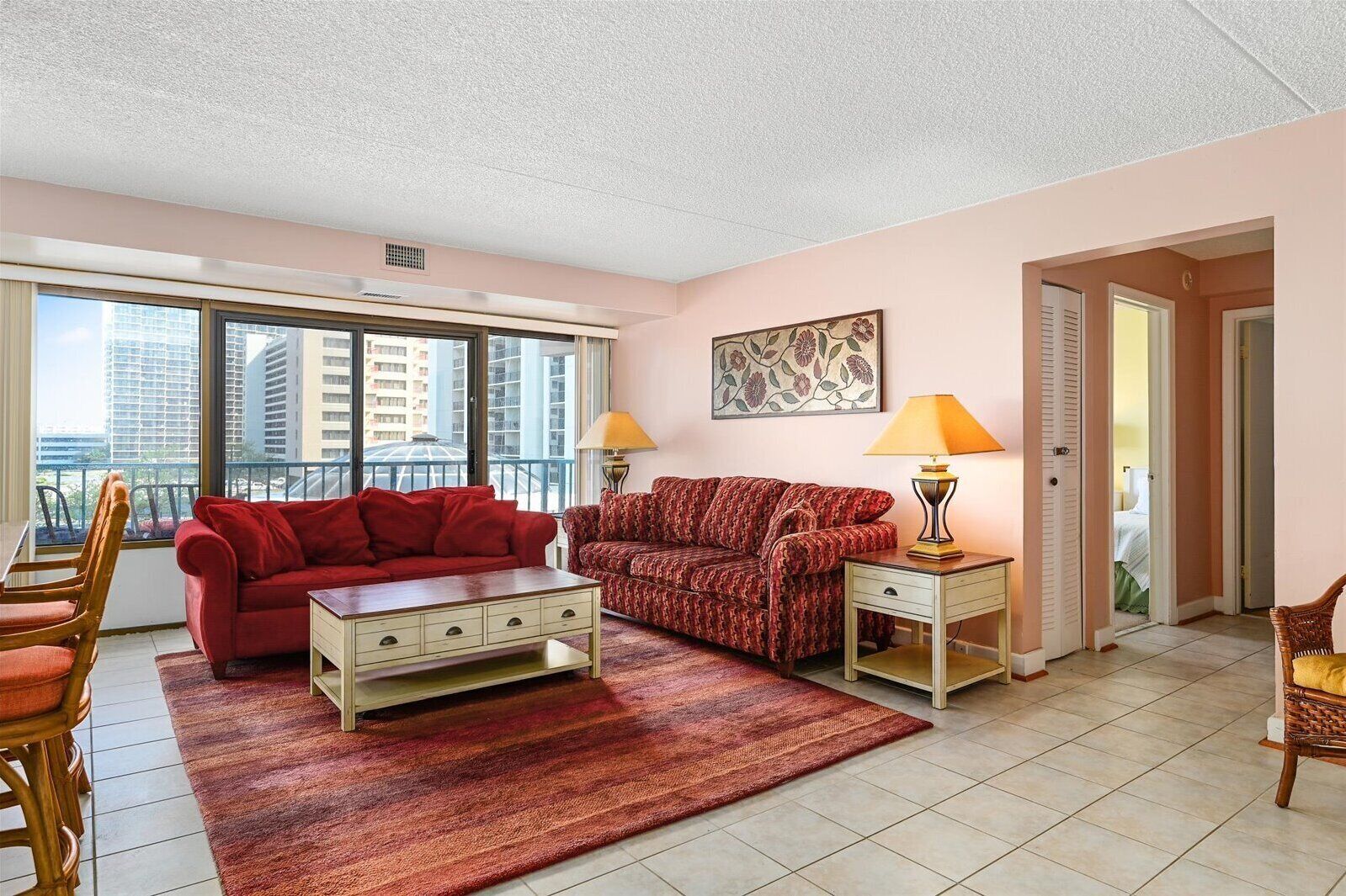 A living room with two sofas, a coffee table, and a rug. There are two lamps on side tables.