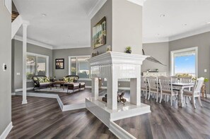 A spacious living area with a fireplace, dining table, and comfortable seating. - Large Direct Bayfront Home with Great Amenities (Berlin)