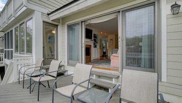 A covered deck with outdoor seating and a view into the house. - 43 Fairway Dunes by AvantStay | Coastal Charm + Golf! (Isle Of Palms)