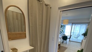 A modern bathroom with a wooden floor, a mirror, a shelf, a step, and a shower curtain. - Sète! 50m2 new parking wifi quay Town center (Sète)