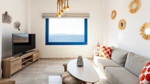 Un soggiorno moderno con televisore, divano e tavolino.