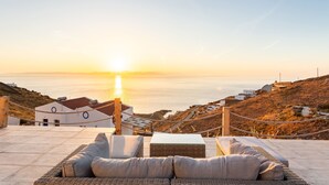 A terrace with wicker furniture and a view of the sunset over the sea. - Live In Blue - Uranian Private Pool & Magic Views (Coressia)
