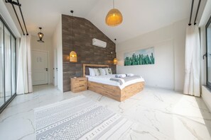 Ein modernes Schlafzimmer mit einem großen Bett, einem Holz-Kopfbrett und einer Wand-Klimaanlage.