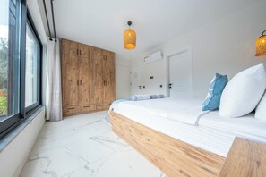 A bedroom with a large bed, wooden wardrobe, and a window with curtains. - Olive Hills Villa Family-Friendly Luxury Villa with Private Pool in Fethiye (Fethiye)