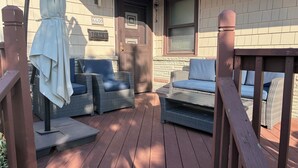 A covered outdoor seating area with wicker furniture and a wooden deck. - Spacious 2-bedroom apt in the Crest, 3 blocks from the beach (Wildwood Crest)