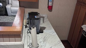 A kitchen with a marble countertop, a coffee maker, a paper towel holder, and a fire extinguisher. - Spacious 2-bedroom apt in the Crest, 3 blocks from the beach (Wildwood Crest)