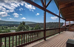 Une terrasse en bois offrant une vue sur un paysage montagneux.