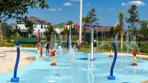 A water play area with multiple water jets and colorful play structures.