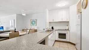 Una cocina moderna con armarios blancos, encimera de granito y horno empotrado.