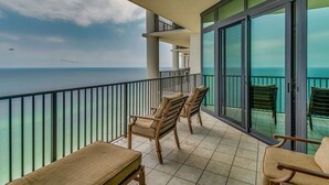 A balcony with a view of the ocean, furnished with two chairs and a bench. - Gulf Front - 3BR 4BA - Lazy River - The Oasis at Orange Beach (Orange Beach)