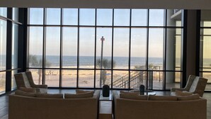 A spacious living area with large windows overlooking a beach, featuring two sofas and a coffee table. - Gulf Front - 3BR 4BA - Lazy River - The Oasis at Orange Beach (Orange Beach)