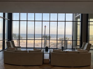 A spacious living area with large windows overlooking a beach, featuring two sofas and a coffee table. - Gulf Front - 3BR 4BA - Lazy River - The Oasis at Orange Beach (Orange Beach)