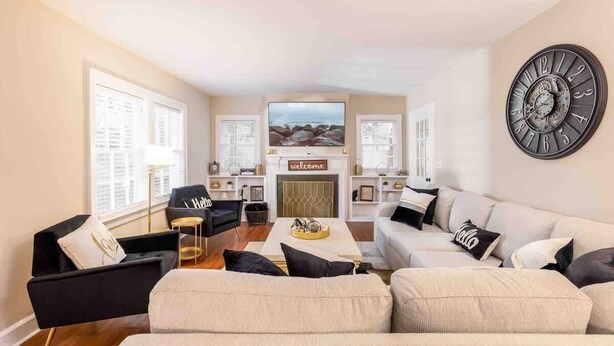 Sala moderna com lareira, um relógio na parede e vista para o exterior.