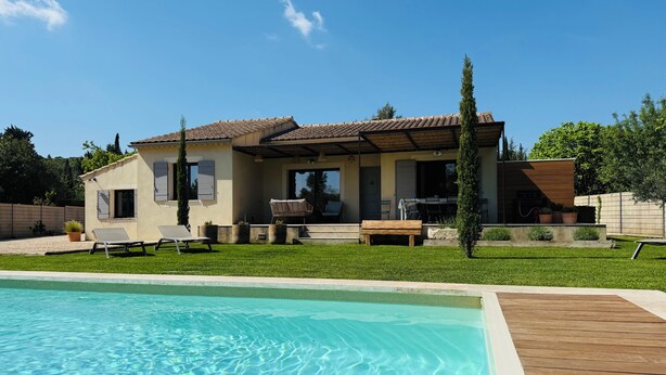 Una casa con piscina, un patio y un espacio techado para sentarse al aire libre.