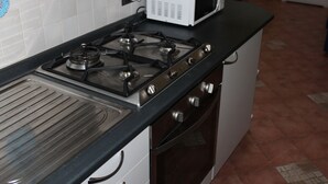 A kitchen with a gas stove, a microwave, and an oven. - Loft Angela Charming Aptmnt in Pietrasanta Center (Pietrasanta)