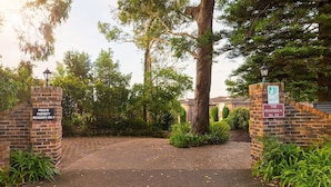 A private property entrance with a brick wall, a sign indicating 'Private Property Residents Only', and a street lamp. - Soldiers Point Absolute Waterfront The Peninsula (Soldiers Point)