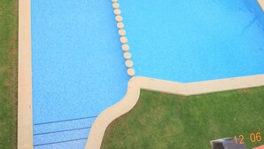 Ein rechteckiger Pool mit einer gefliesten Kante und einer Reihe kreisförmiger Markierungen an einer Seite.