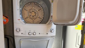 Eine kompakte, weiße Waschmaschine mit Frontlader, einer Bedienblende mit verschiedenen Einstellungen und einem kleinen Staufach.
