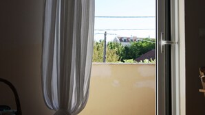 A room with a sliding glass door leading to a balcony.