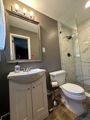 Tina con regadera, toallas, papel de baño 