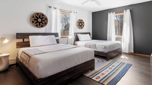 Un dormitorio con dos camas, ventilador de techo y vistas al exterior.