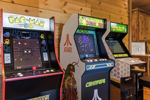 Trois bornes d’arcade : Pac-Man, Centipede et Golden Tee 3D Golf.