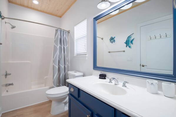 Et moderne badeværelse med badekar, toilet og håndvask.