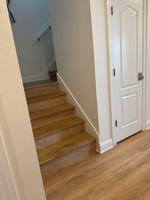 Un escalier avec des marches en bois menant à une porte blanche.