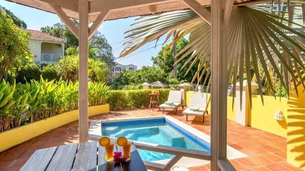 A pool area with a pergola, lounge chairs, and a table with drinks. - Woodlands Luxury Villas (Mullins)