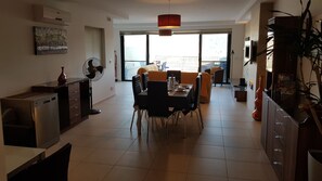 A spacious dining area with a large table, chairs, and a modern pendant light.