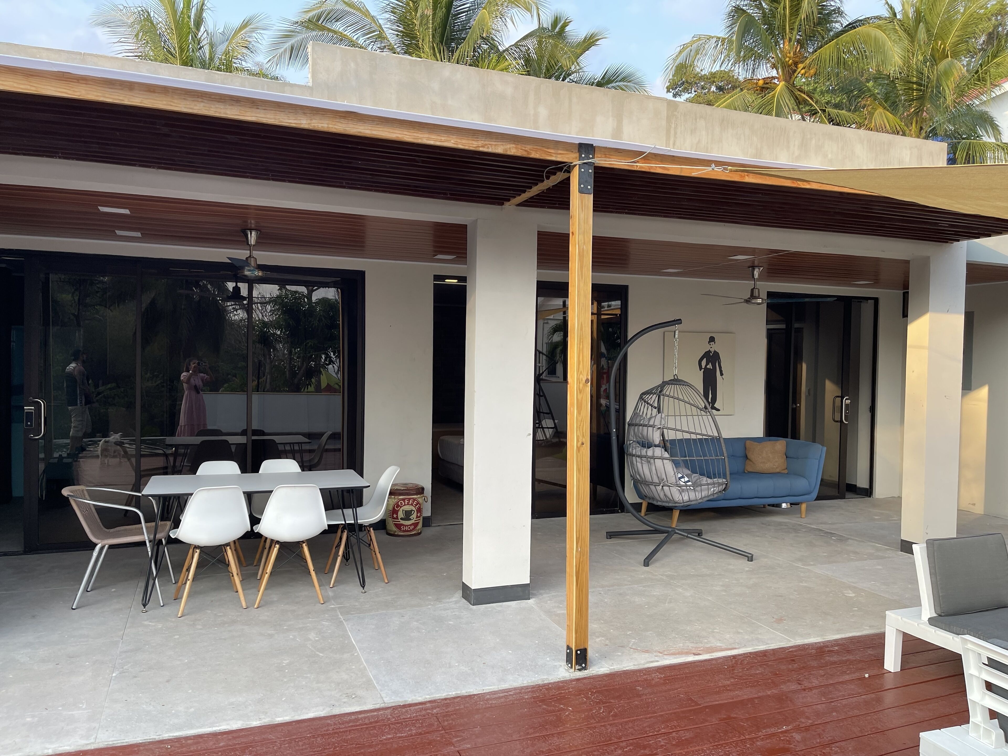 Eine moderne Außenpatio mit Essbereich, einer Hängematte und einem blauen Sofa.