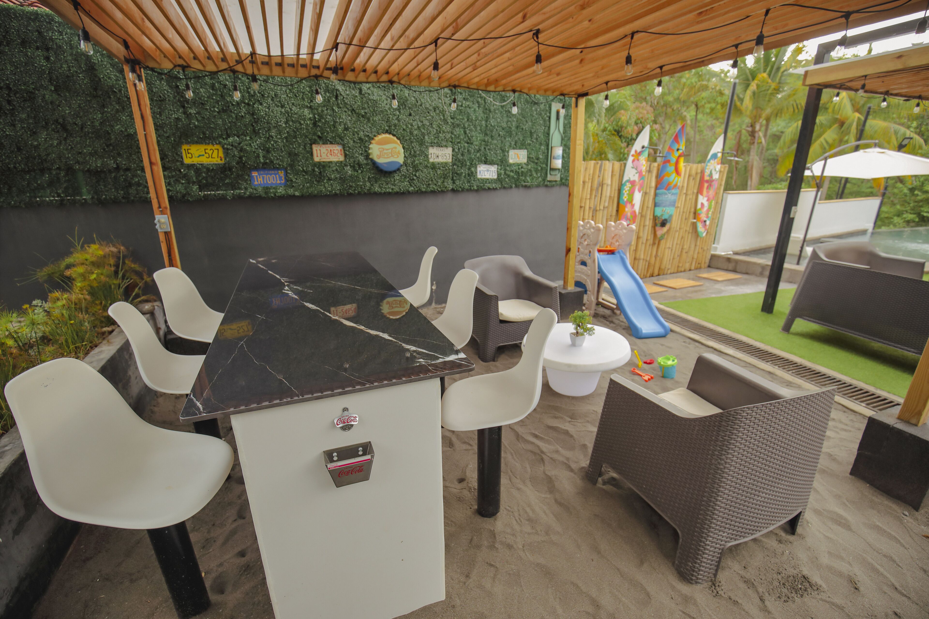 An outdoor seating area with a table, chairs, and a small play area for children.