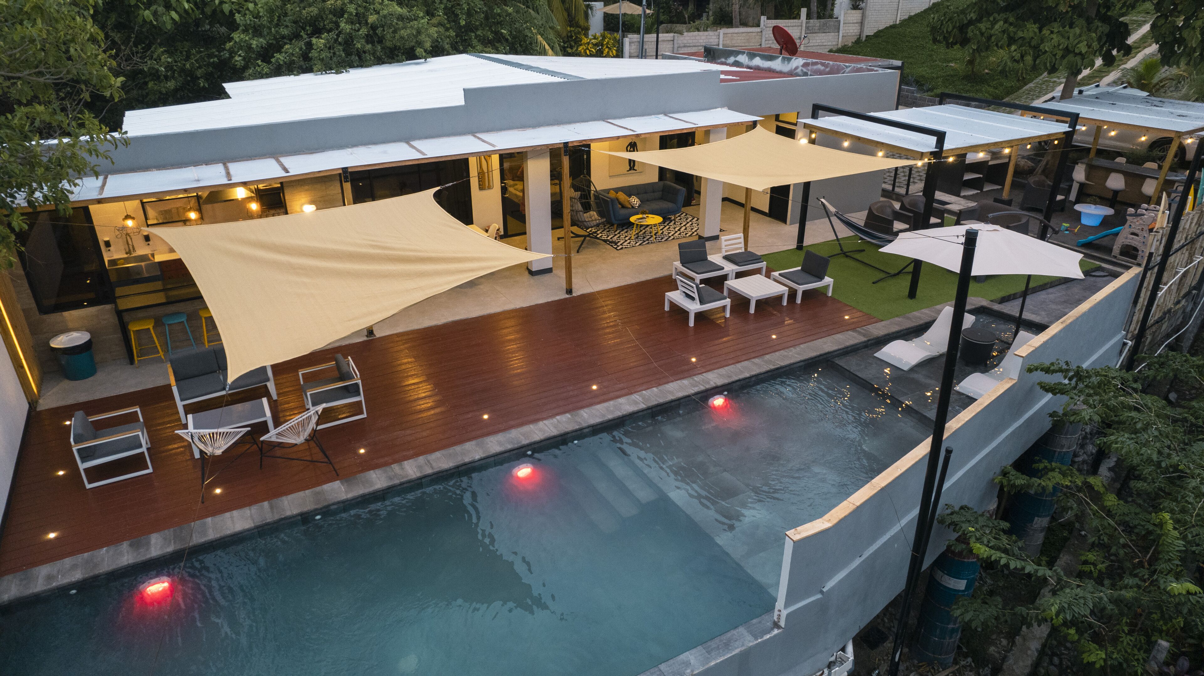 Ein Poolbereich auf dem Dach mit Sitzgelegenheiten und einer überdachten Terrasse.